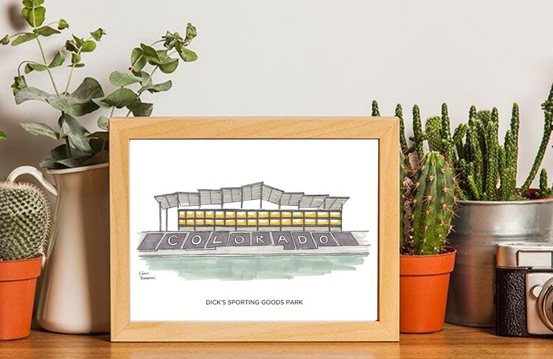 K&ouml;nnte beinhalten: Ein gerahmter Druck einer handgezeichneten Illustration eines Stadions mit dem Wort "COLORADO" auf der Vorderseite. Der Text "Dick's Sporting Goods Park" ist unter der Illustration gedruckt.