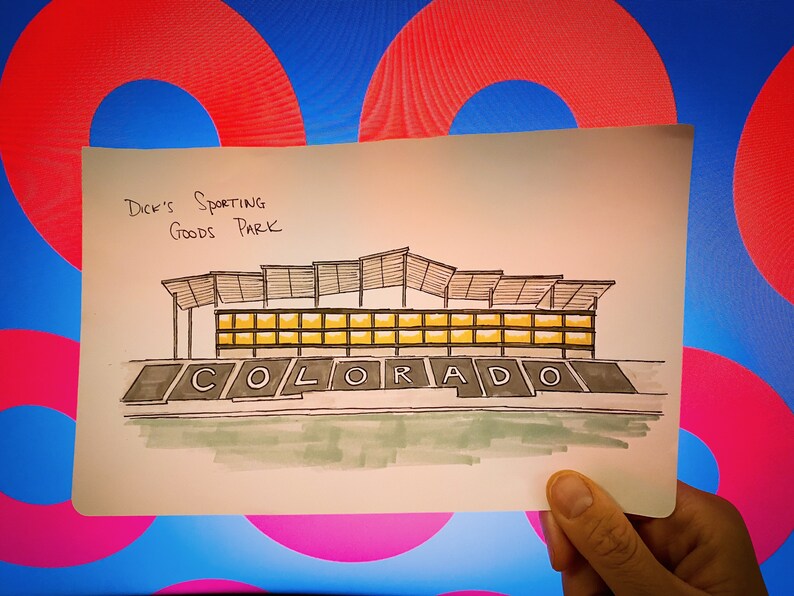K&ouml;nnte beinhalten: Eine handgezeichnete Illustration eines Geb&auml;udes mit dem Text "Dick's Sporting Goods Park" und "COLORADO" darunter.