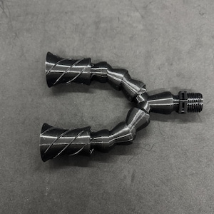 Könnte beinhalten: Eine schwarze, flexible Sprühdüse mit zwei verstellbaren Sprühköpfen. Die Düse besteht aus einer Reihe von miteinander verbundenen Segmenten, die es ihr ermöglichen, sich zu biegen und in verschiedene Richtungen zu bewegen.