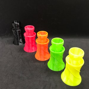 May include: Five colorful plastic funnels with a spiral design. The funnels are black, red, orange, green, and yellow.