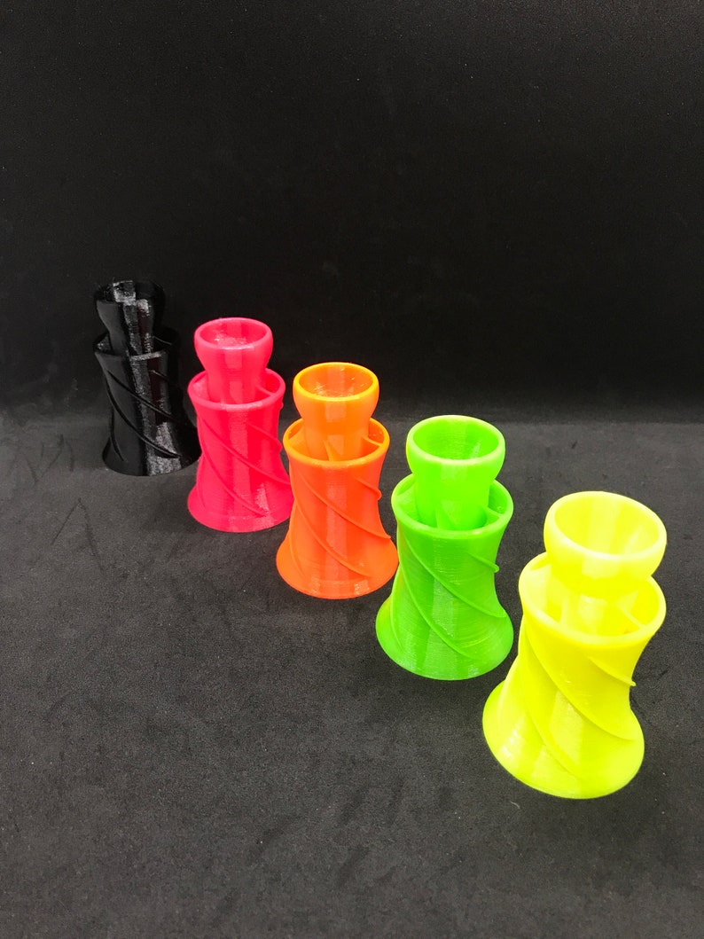 May include: Five colorful plastic funnels with a spiral design. The funnels are black, red, orange, green, and yellow.