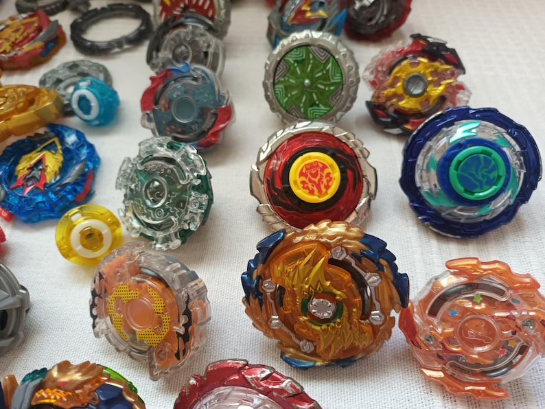 Op de afbeelding: Een verzameling kleurrijke tolletjes in verschillende ontwerpen. De tolletjes hebben een mix van kleuren, waaronder blauw, rood, groen, geel en oranje. Sommige hebben ingewikkelde patronen en ontwerpen.