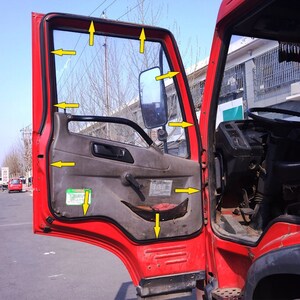 May include: A red truck door with a black rubber seal around the window. The door is open and the interior of the truck is visible. The door has a black handle and a black latch. The window is made of clear glass and has a black frame.