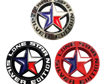 May include: Three Lone Star Silver Edition emblems with a five-pointed star in the center. The emblems are black, silver, and red with a blue, white, and red star.