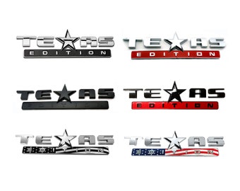 May include: Six different versions of a "Texas Edition" emblem. The emblems are made of metal and feature a star and the words "Texas Edition". The emblems are in different colors, including silver, red, black, and a combination of silver and red, white, and blue.