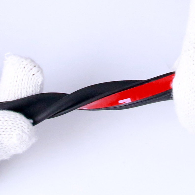 May include: Black rubber weather stripping with a red adhesive backing. The stripping is flexible and can be bent to fit different shapes.