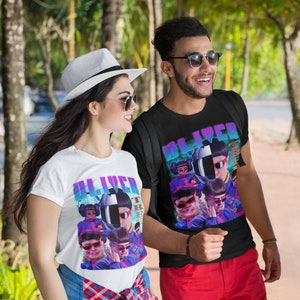 May include: Two people wearing t-shirts with a graphic print of a person wearing a helmet and sunglasses. The text "Oliver" is printed on the shirts. The people are walking on a pavement.