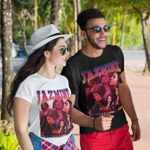 Puede incluir: Una pareja vistiendo camisetas blancas y negras con una impresión gráfica del texto "Jazmine Sullivan" y un collage de imágenes de mujeres. El hombre lleva pantalones cortos rojos y gafas de sol. La mujer lleva un sombrero blanco y gafas de sol.