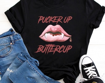 May include: Black t-shirt with a red graphic of a vampire mouth with fangs and the text "Pucker Up Buttercup".