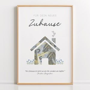 Op de afbeelding: Een wit ingelijst afdruk met een huis gemaakt van eurobiljetten. De tekst "FÜR DEIN NEUES Zuhause" staat bovenaan de afdruk. De quote "Ein Zuhause ist nicht nur ein Ort, sondern ein Gefühl." staat onderaan de afdruk. De quote wordt toegeschreven aan Christian Morgenstern.