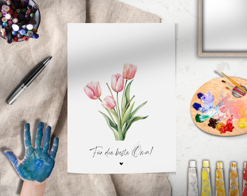May include: A white card with a bouquet of pink tulips and the text "F&uuml;r die beste Oma!"  A small heart symbol is below the text.
