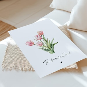 May include: A white card with a watercolor illustration of pink tulips and the text "For the best Oma!" in black cursive.