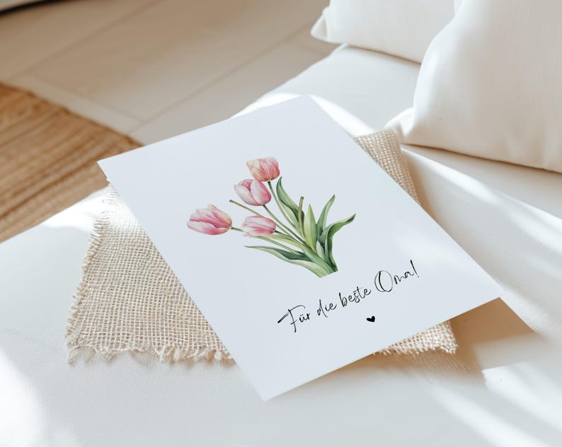 May include: A white card with a watercolor illustration of pink tulips and the text "For the best Oma!" in black cursive.