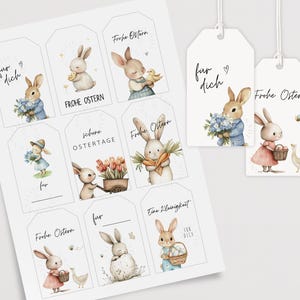 Könnte beinhalten: Ein Blatt mit druckbaren Ostergeschenkanhängern mit niedlichen Hasenillustrationen. Die Anhänger haben verschiedene Ostergrüße auf Deutsch, darunter "Frohe Ostern" und "Schone Ostertage".