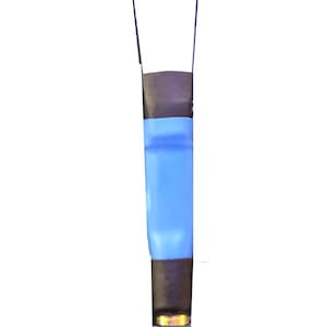 May include: A brown and blue clarinet reed with a gold tip. The reed is sitting on a white surface.