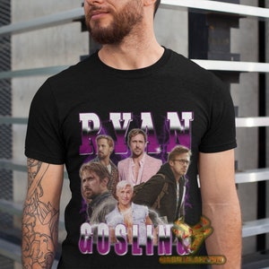 May include: Black t-shirt with a graphic print of Ryan Gosling's face in a collage of different images. The text "RYAN GOSLING" is printed in purple letters.