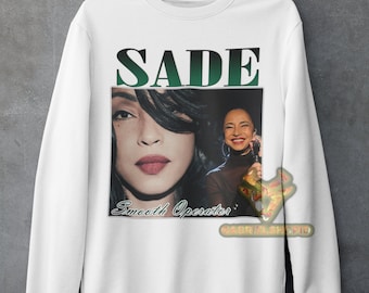 May include: White sweatshirt with a green and black graphic print of Sade. The graphic includes a photo of Sade and the text "SADE" and "Smooth Operator".