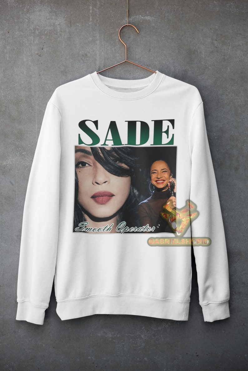 May include: White sweatshirt with a green and black graphic print of Sade. The graphic includes a photo of Sade and the text "SADE" and "Smooth Operator".