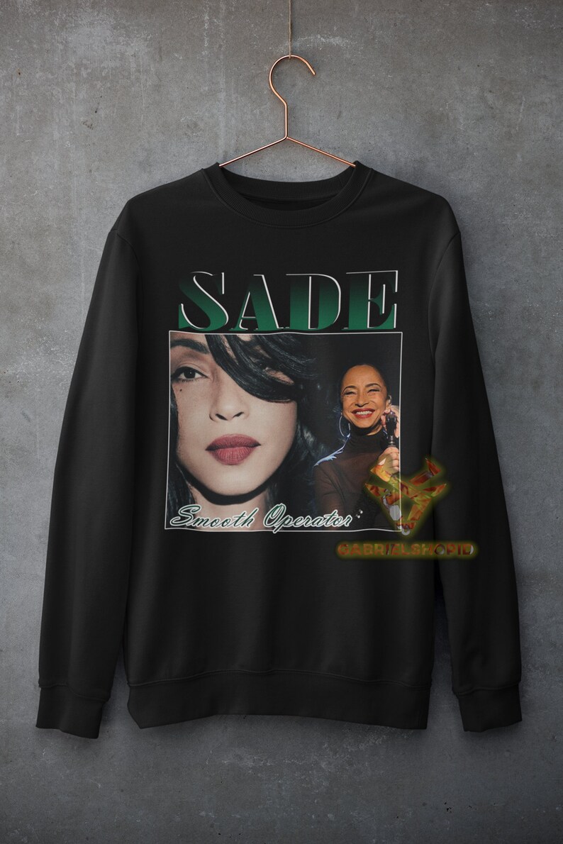 May include: Black sweatshirt with a vintage-style graphic of Sade, a singer, with the text "SADE" and "Smooth Operator" printed on the front.