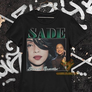 May include: Black t-shirt with a green and white graphic of Sade with the text "SADE" and "Smooth Operator".