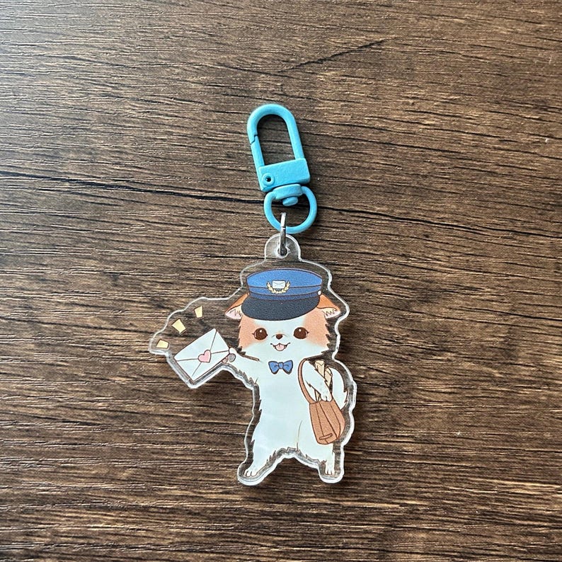 May include: A clear acrylic keyring featuring a cartoon dog dressed as a mail carrier. The dog is wearing a blue hat and bow tie, carrying a mailbag and a letter with a heart. The keyring has a blue clasp.