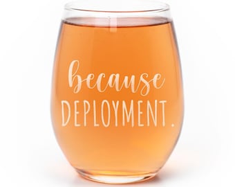 May include: A stemless wine glass filled with a light orange liquid. The glass features white text printed on the front that reads because DEPLOYMENT. The design uses a combination of a cursive script font and a simple sans-serif typeface.