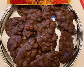 Chocolate nut clusters handmade in a red tin with an art postcard