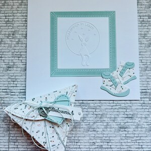 SET (Karte + Verpackung) zur Geburt mit Prägemotiv „Hase" u. Text: "Willkommen im Leben“ in Weiß-Hellblau, Stanzmotiv "Babyschuhe" handmade