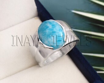 Könnte beinhalten: Ein silberner Ring mit einem großen ovalen blauen und weißen Edelstein. Der Ring hat ein einzigartiges Design mit einem gebogenen Band.
