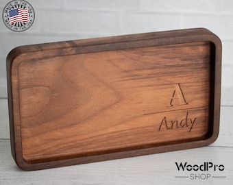 Könnte beinhalten: Ein rechteckiges Serviertablett aus Holz mit abgerundeten Kanten. Das Tablett ist mit dem Buchstaben "A" über dem Namen "Andy" graviert. Das Holz hat eine satte, dunkelbraune Farbe. Das Logo "Made in the USA" ist sichtbar.