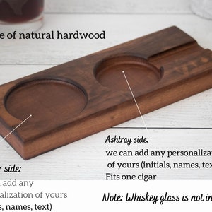 May include: A wooden tray with two round indentations for coasters and a rectangular indentation for an ashtray. The tray is made of natural hardwood and can be personalized with initials, names, or text. "Coaster side: we can add any personalization of yours (initials, names, text)" and "Ashtray side: we can add any personalization of yours (initials, names, text) Fits one cigar" are written on the tray. "Note: Whiskey glass is not included" is written below the tray.