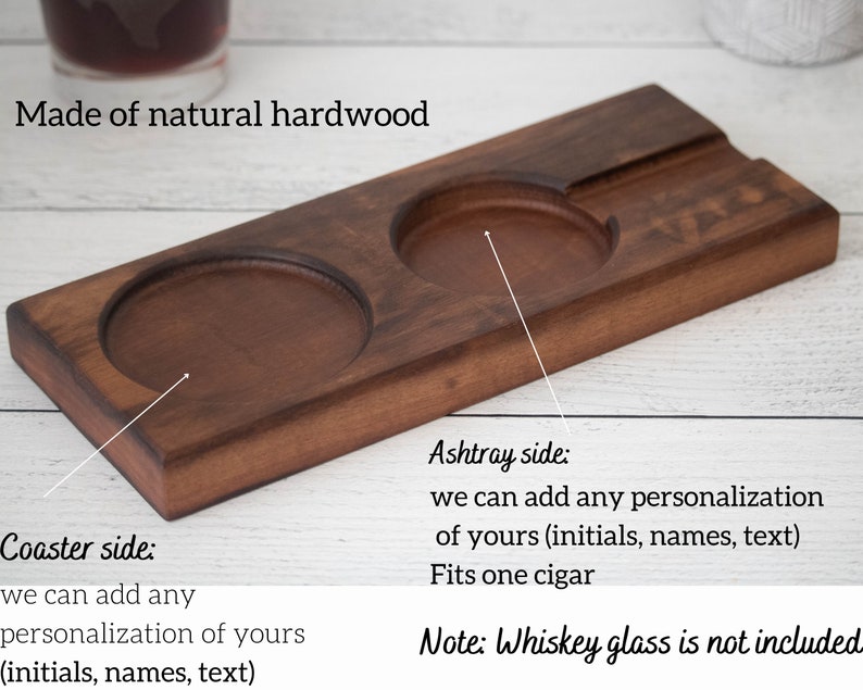 May include: A wooden tray with two round indentations for coasters and a rectangular indentation for an ashtray. The tray is made of natural hardwood and can be personalized with initials, names, or text. "Coaster side: we can add any personalization of yours (initials, names, text)" and "Ashtray side: we can add any personalization of yours (initials, names, text) Fits one cigar" are written on the tray. "Note: Whiskey glass is not included" is written below the tray.