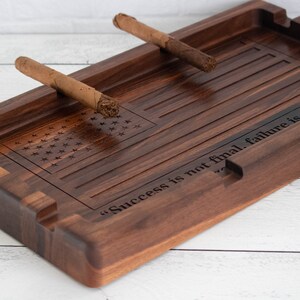 May include: A wooden cigar ashtray with an American flag design and the quote "Success is not final, failure is not fatal." engraved on the side.