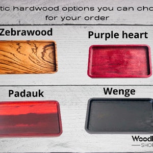 May include: Four wooden trays in different exotic wood types: zebrawood, purple heart, padauk, and wenge. The trays are all rectangular and have a smooth, polished finish.