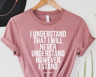 Puede incluir: Una camiseta rosa polvorienta con el texto "I understand that I will never understand however I stand" impreso en blanco.