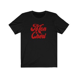 May include: Black t-shirt with a red graphic that says "Mon Ch&eacute;ri" in a retro font.