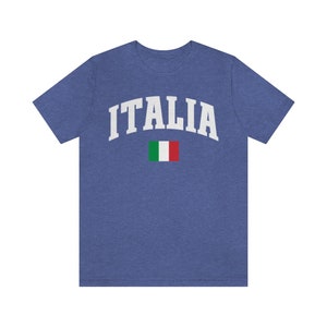 Pu&ograve; includere: Una maglietta blu con la scritta "ITALIA" in bianco sul petto. La bandiera italiana &egrave; stampata sotto il testo.