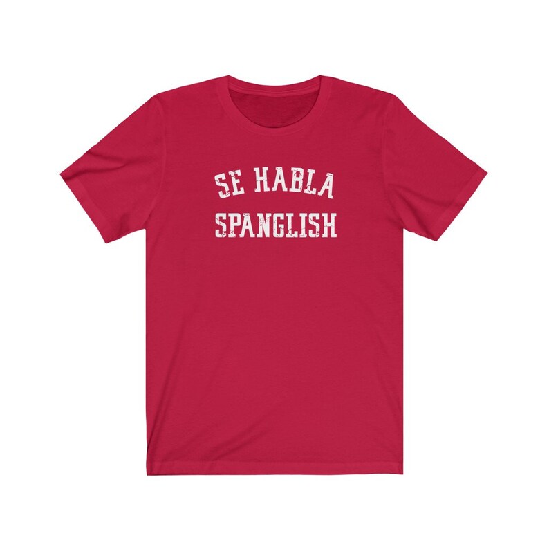 May include: Red short-sleeved t-shirt with white text that reads "Se Habla Spanglish".