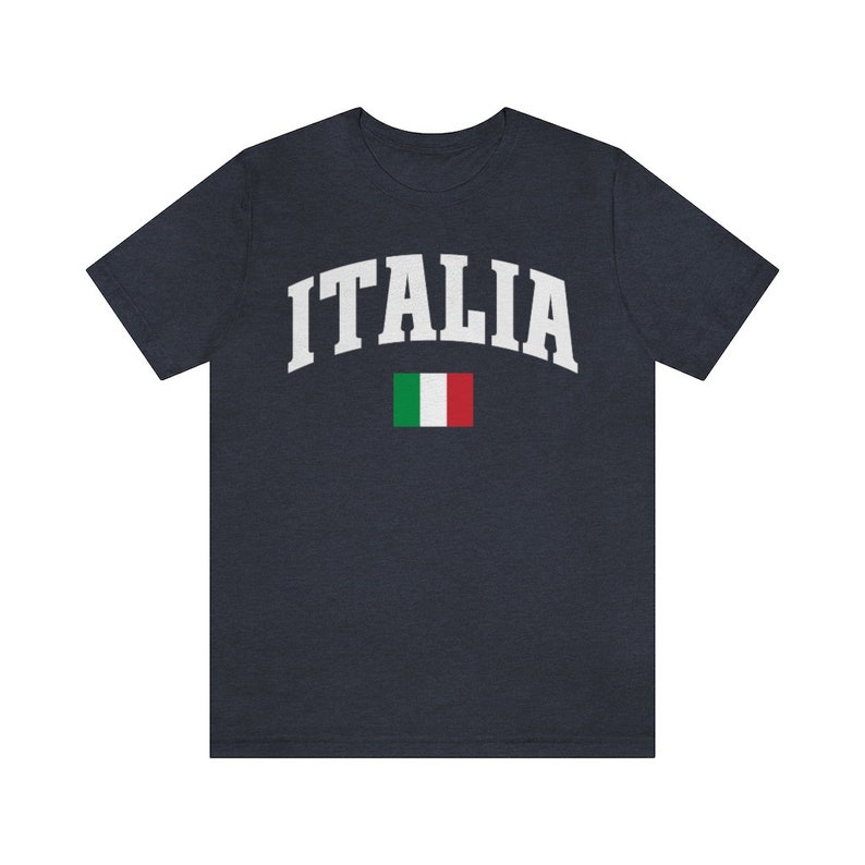 Pu&ograve; includere: Una maglietta blu navy con la scritta "ITALIA" in bianco in un font ad arco. La bandiera italiana &egrave; sotto il testo.
