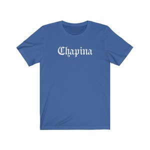 May include: A royal blue t-shirt with a white graphic that says "Chapina" in a gothic font.