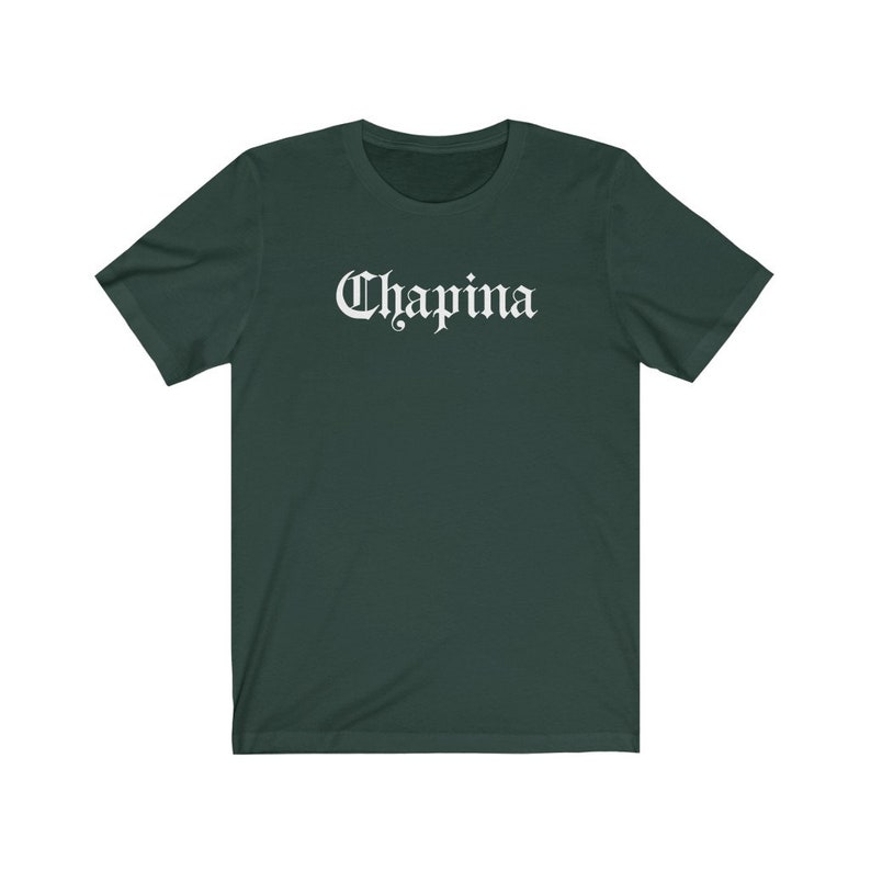 May include: A dark green t-shirt with the word "Chapina" printed in white on the front in a gothic font.