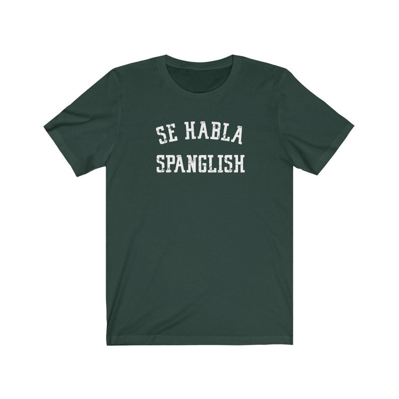 May include: A dark green t-shirt with the text "SE HABLA SPANGLISH" printed in white.