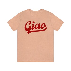May include: A light peach colored t-shirt with a red stylized word "Ciao" printed on the front.