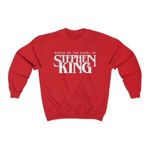 May include: Red sweatshirt with white text that reads "Based on the novel by Stephen King".