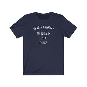 May include: A navy blue t-shirt with white text that reads "Mi hija favorita me regal&oacute; esta camisa".