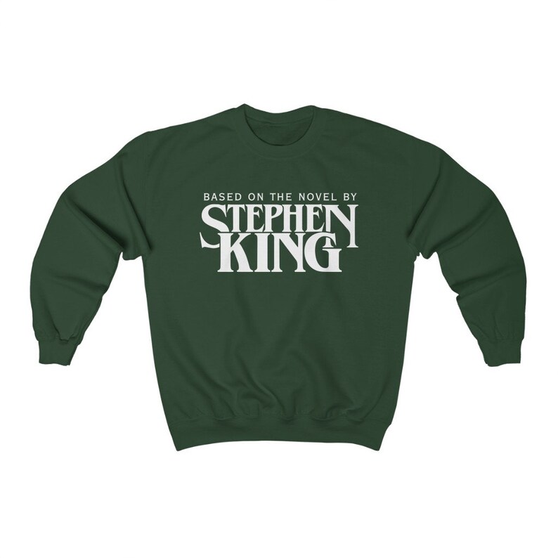 May include: A dark green sweatshirt with white text that reads "Based on the novel by Stephen King".