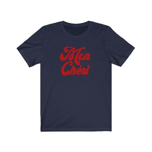 May include: Navy blue t-shirt with a red retro-style graphic that says "Mon Ch&eacute;ri".
