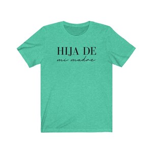 May include: A teal green t-shirt with the text "HIJA DE mi madre" in black.