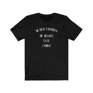 May include: Black t-shirt with white text that reads "Mi hija favorita me regal&oacute; esta camisa".