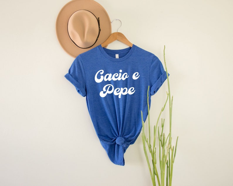 May include: A blue t-shirt with the text "Cacio e Pepe" in white retro-style lettering.